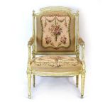 A Louis XVI-style cream and gilt highlighted salon armchair with a floral upholstered seat and back
