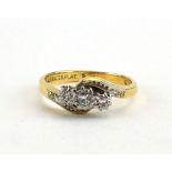 An 18ct yellow gold and platinum highlighted crossover ring set three small graduated diamonds in