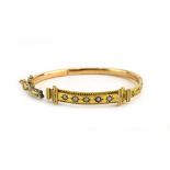 An early 20th century 15ct yellow gold hinged bracelet of Etruscan design set three small diamonds
