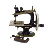 A miniature table-top 'Singer for Girls' sewing machine with a black lacquer body,