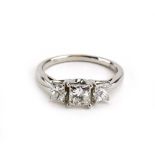 An 18ct white gold ring set three graduated princess cut diamonds in a raised tiered setting,