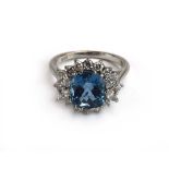 An 18ct white gold cluster ring set cushion cut topaz within a border of four marquise and twelve