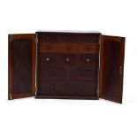 A 19th century mahogany table cabinet, the pair of doors enclosing an arrangement of twelve drawers,