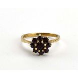 A 9ct yellow gold flowerhead ring set garnet, ring size N,