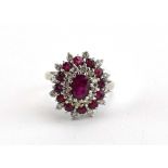 An 18ct white gold cluster ring set oval ruby within three borders of smaller alternating diamonds