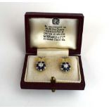 A pair of white metal ear studs, each set a diamond and sapphire cluster, retailed by Garrard, d.
