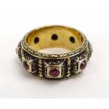 A yellow metal ring of Renaissance design set seven small rubies, ring size I 1/2, 7.