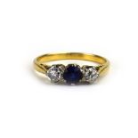 A yellow metal three stone ring set vibrant blue sapphire and two diamonds, stones approximately 0.