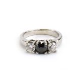 An 18ct white gold ring set black diamond and two brilliant cut white diamonds in an inline setting,