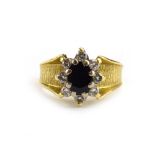 A 1970's yellow metal cluster ring set oval sapphire and four small diamonds within a bark design