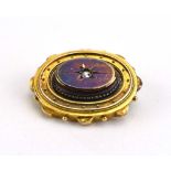 An early 20th century yellow metal mourning brooch of Etruscan design centrally set small pearl
