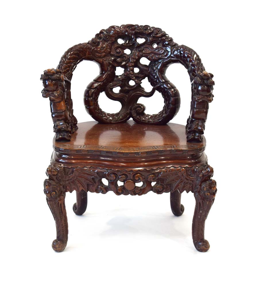 A mid-20th century Oriental hardwood and lacquered chair with intricate dragon carving,