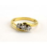 An 18ct yellow gold crossover ring set three graduated diamonds, ring size M 1/2, 3.