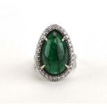 A 14ct white gold ring set pear drop double cabochon cut emerald within a border of small diamonds,