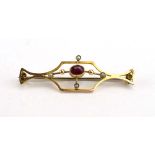 An early 20th century yellow metal bar brooch of openwork design set garnet and seed pearls, w. 4.