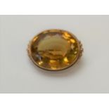 An early 20th century brooch of oval form set facet cut citrine, w. 2.