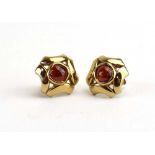 A pair of 9ct yellow gold ear studs, each set cabochon garnet within an openwork setting, w. 1.