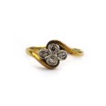 An 18ct yellow gold and platinum highlighted crossover ring set four small diamonds in a clover