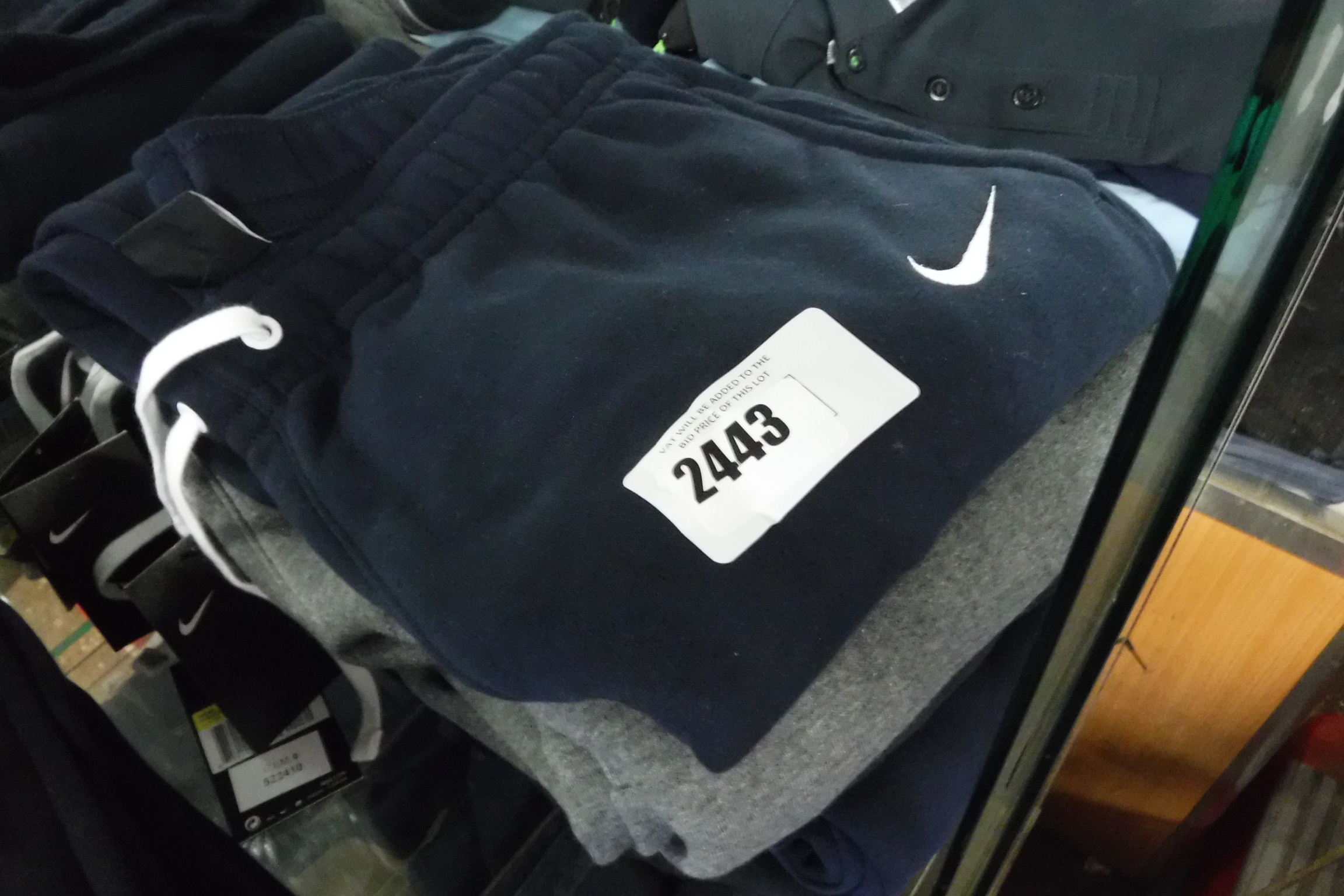 Stack of 5 pairs of Nike tracksuit bottoms in blue, black and grey