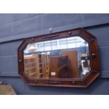 A bevelled mirror in dark oak frame