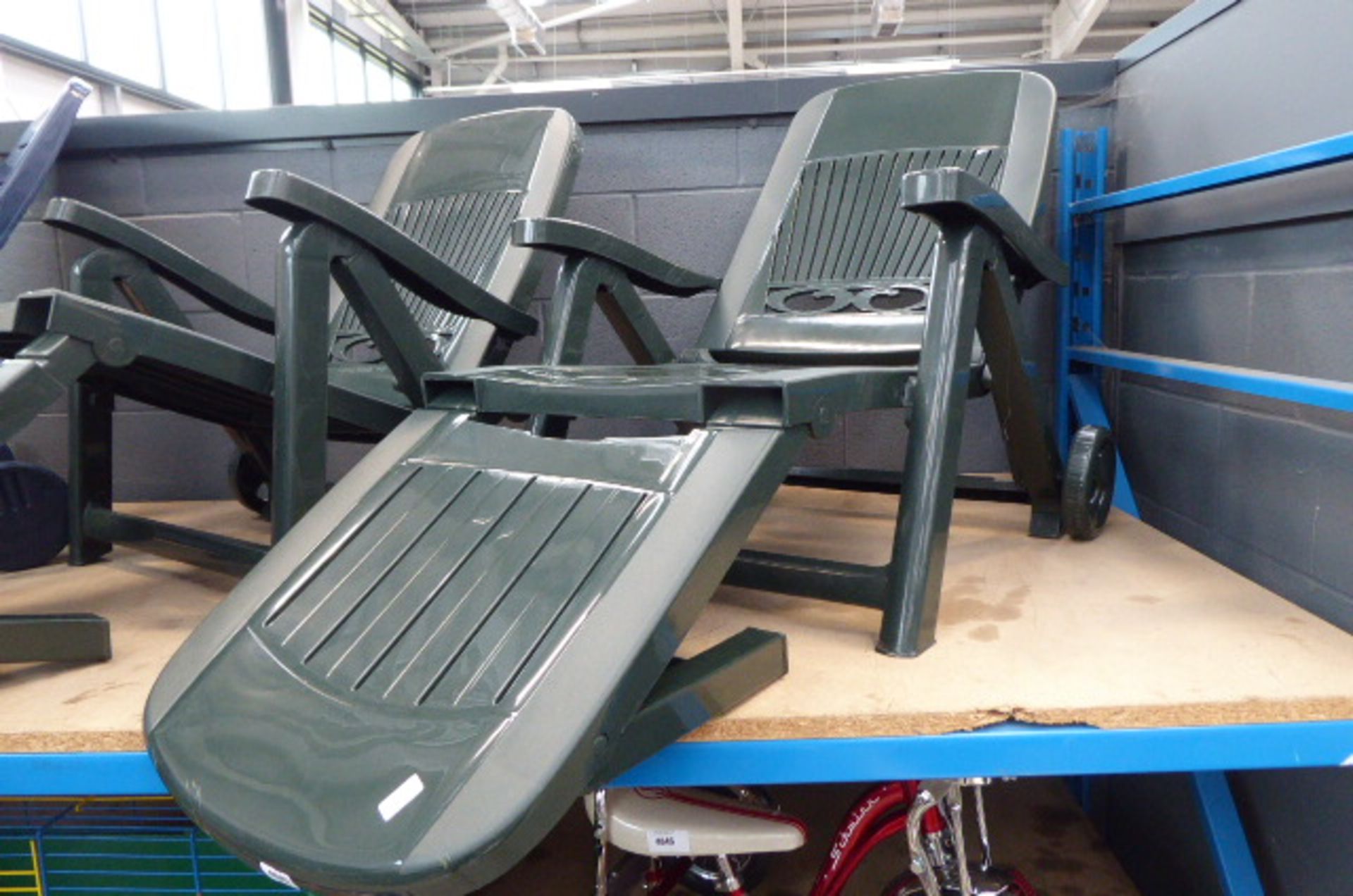 2 green plastic reclining chairs