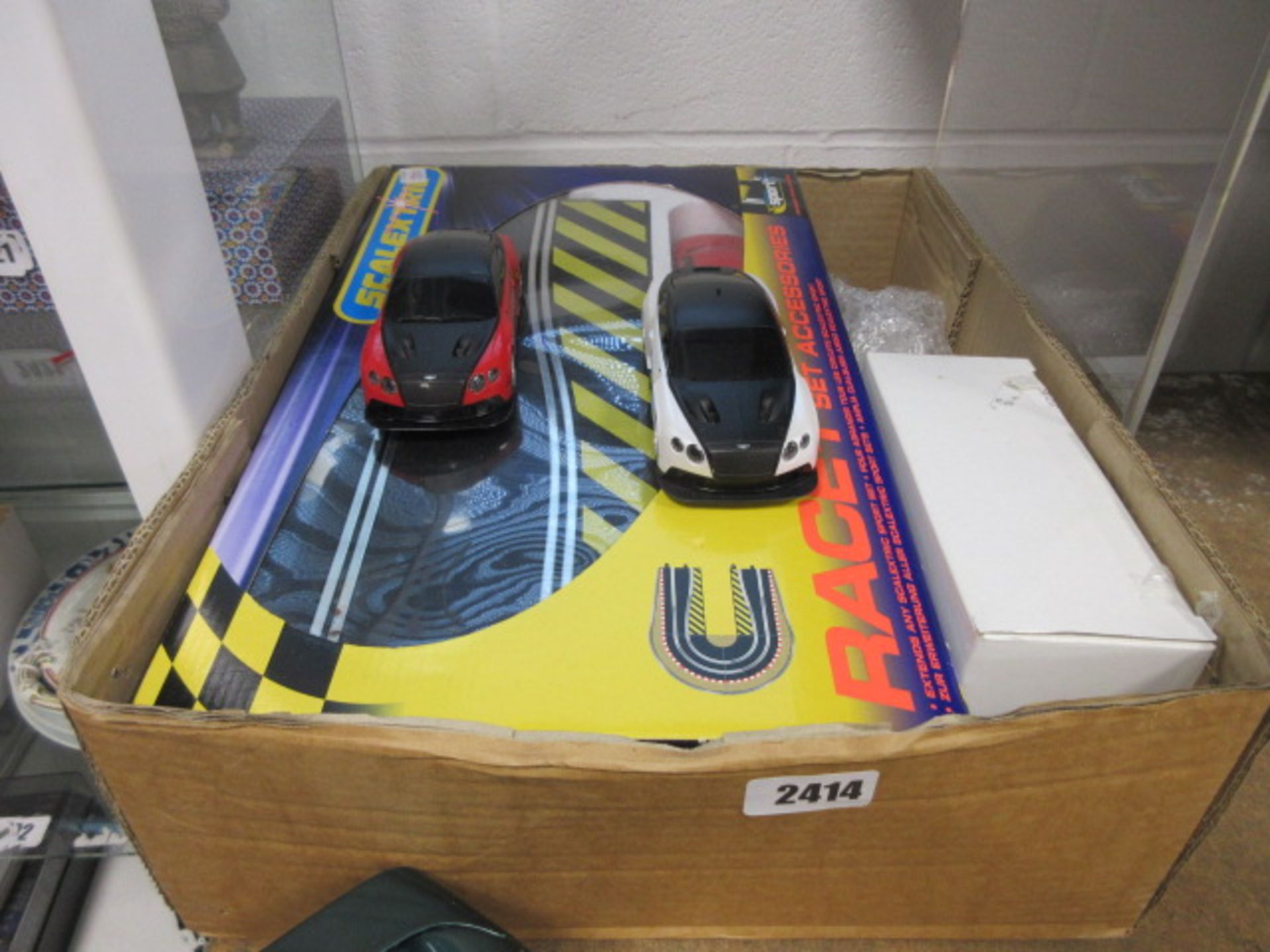 Scalextric model vehicles and other accessories in cardboard box