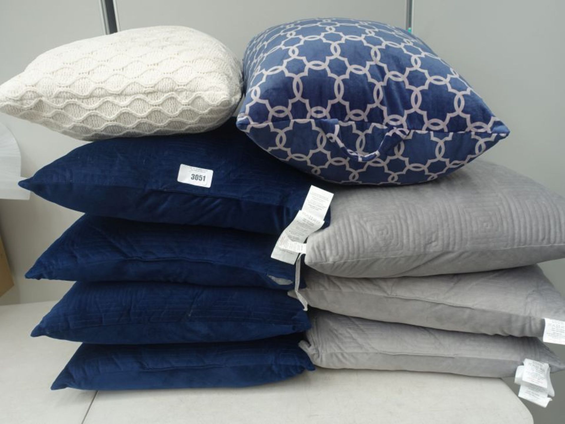 Stack of grey and blue sofa cushions plus 2 other mixed style cushions