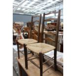 Pair of oak ladderback dining chairs with rush seats