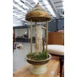 Resin figure of Venus on stand with artificial foliage