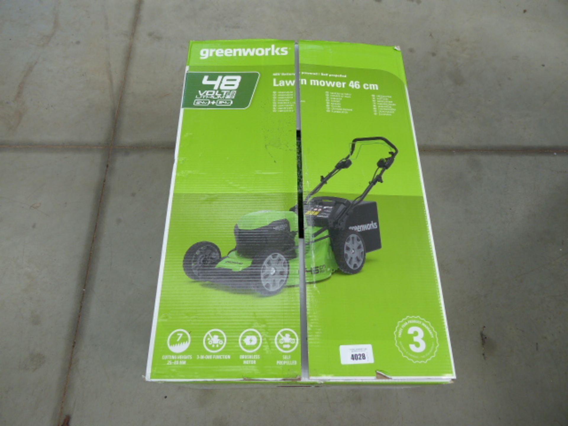 Boxed Greenworks battery powered lawn mower in green with grass box