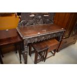 A heavily carved side table, a nest of three oak tables,