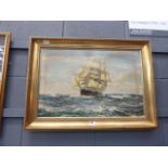 A framed oleograph sailing ship at sea