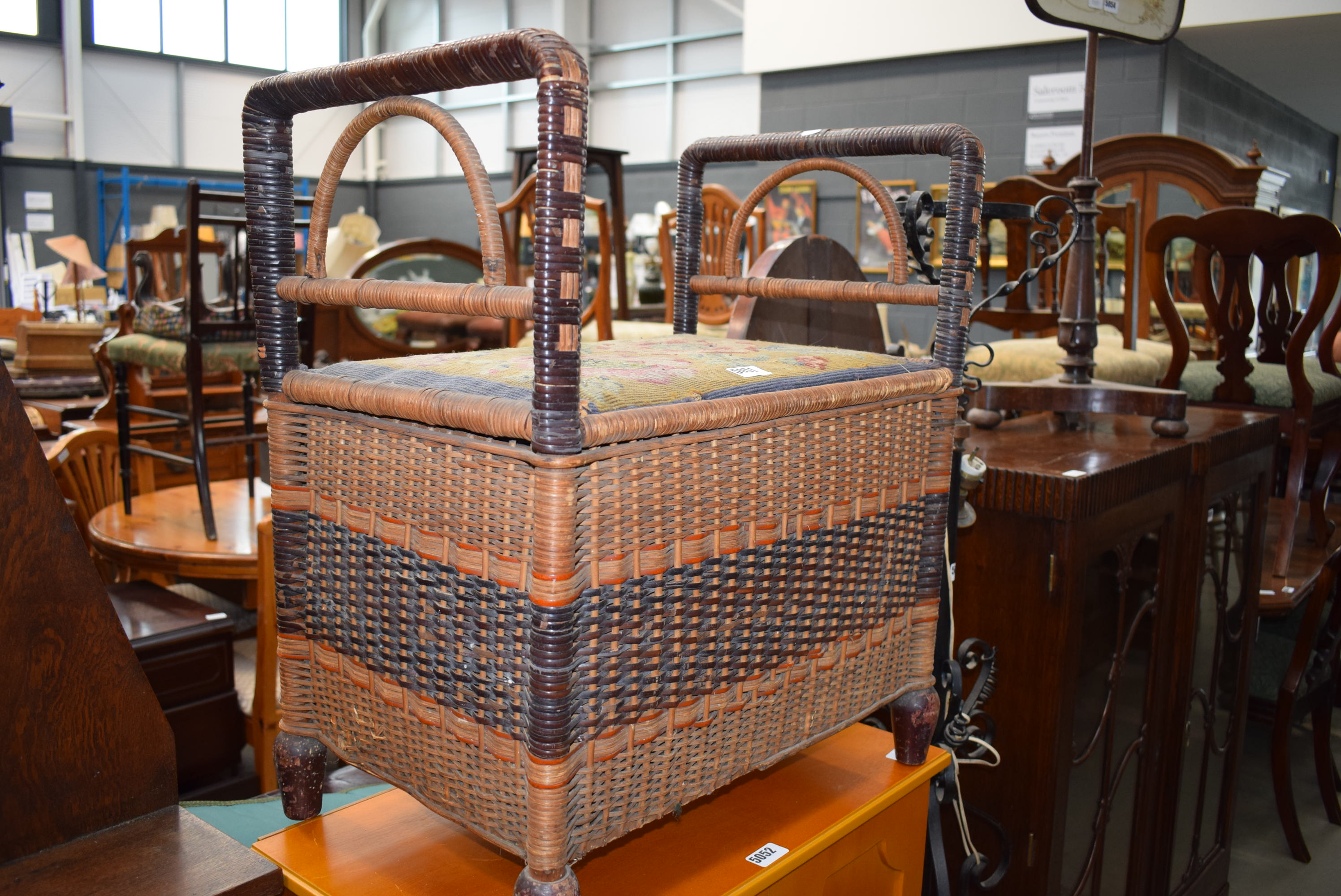 A wicker stool with embroidered seat