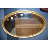 An oval gilt framed wall mirror