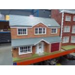 A dolls house with grey roof and garage