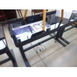 An adjustable black glass work desk