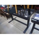 An adjustable black glass work desk