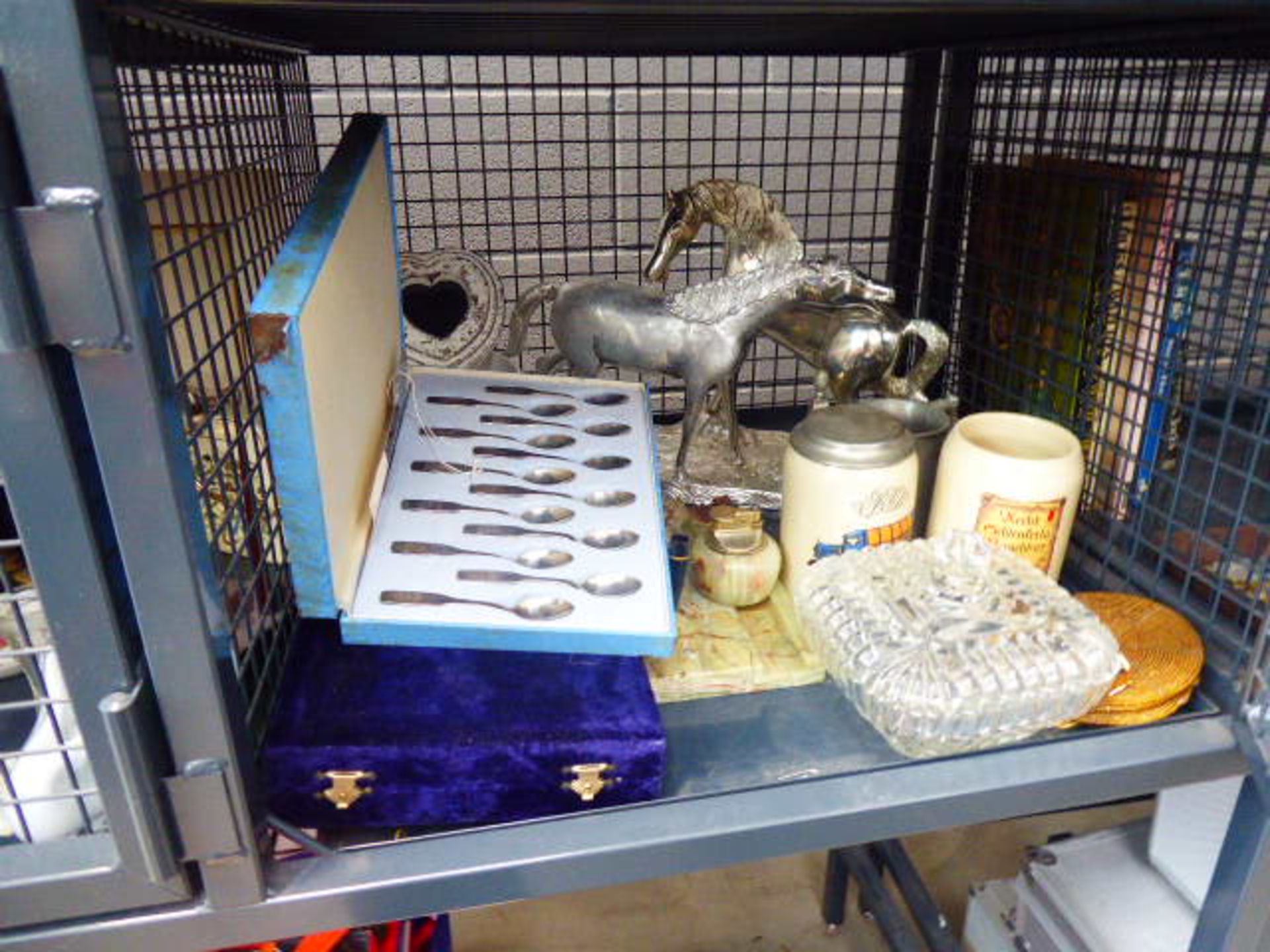 Cage containing ornamental figure with horses, cased cutlery sets, an onyx desk tidy, ale mugs,