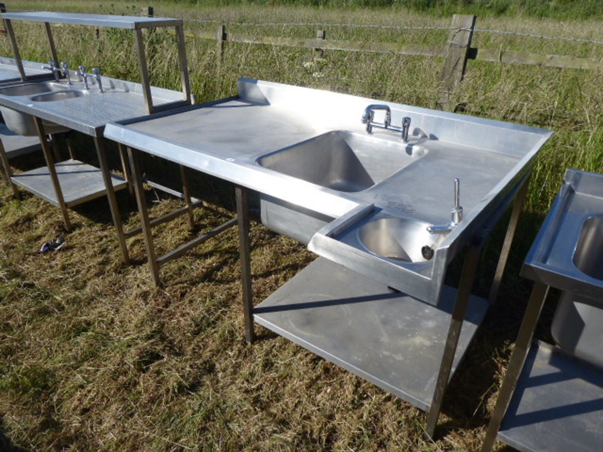 Custom built corner large single bowl sink unit with a small handbasin, tap sets, void under for