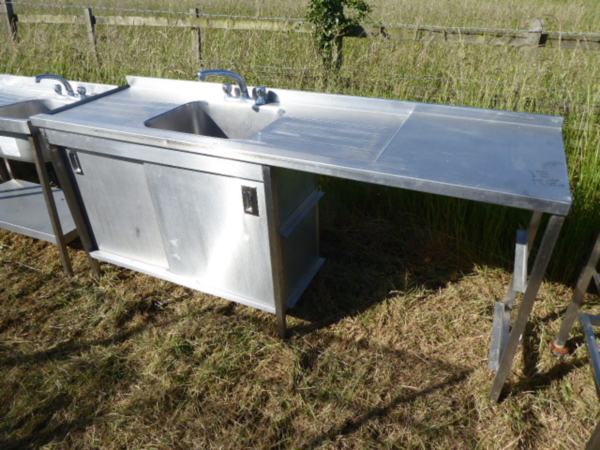 Stainless steel unit with a large single bowl sink and tap set, draining board, food preparation