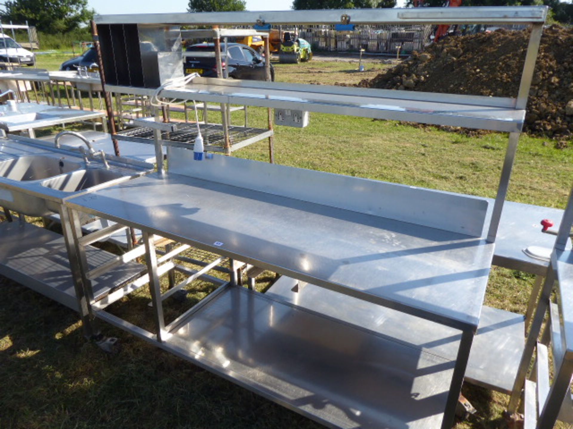 Stainless steel mobile food preparation station with 2 shelves over, shelf under space for trays,