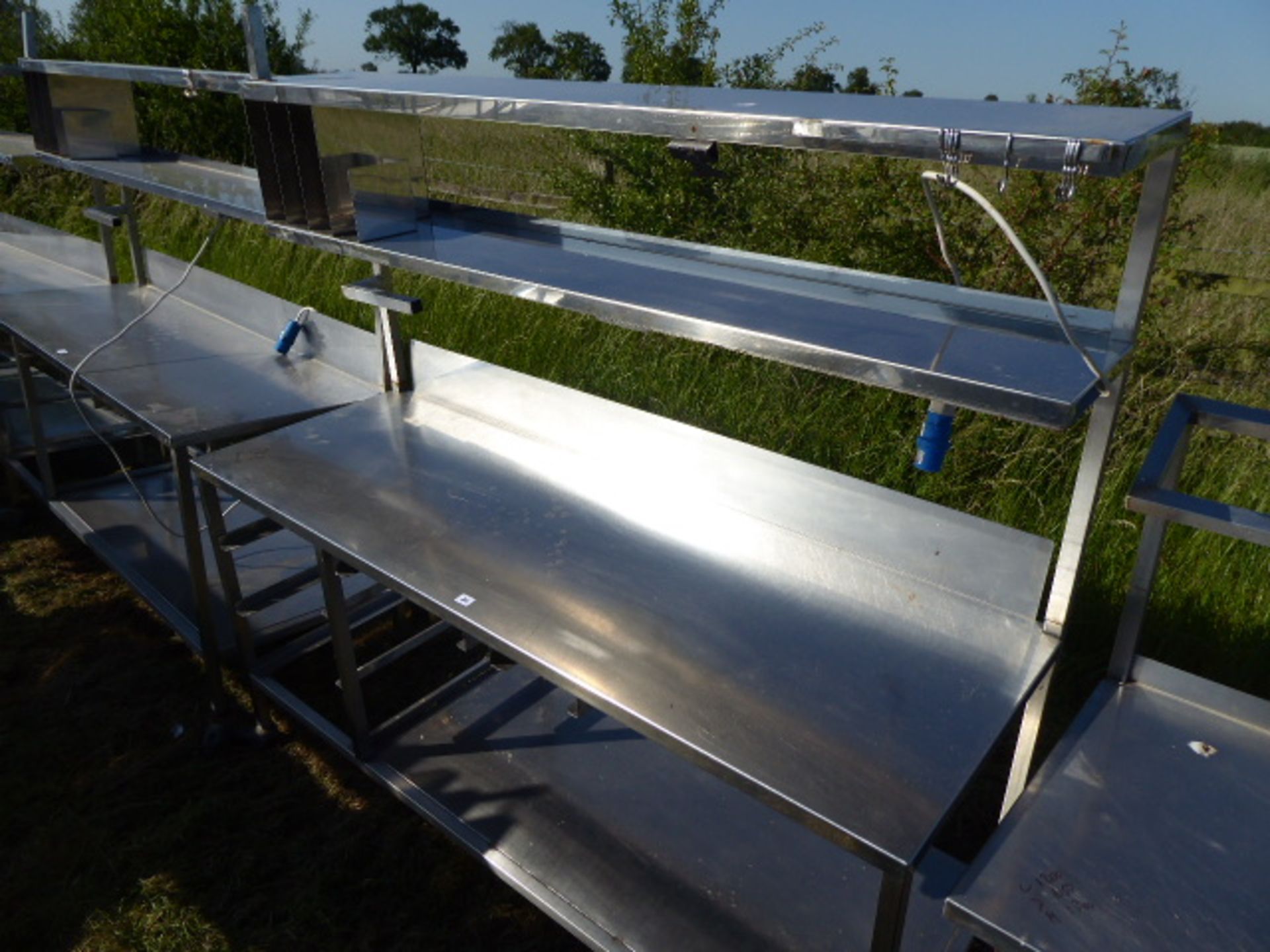 Stainless steel mobile food preparation station with 2 shelves over, shelf under space for trays,