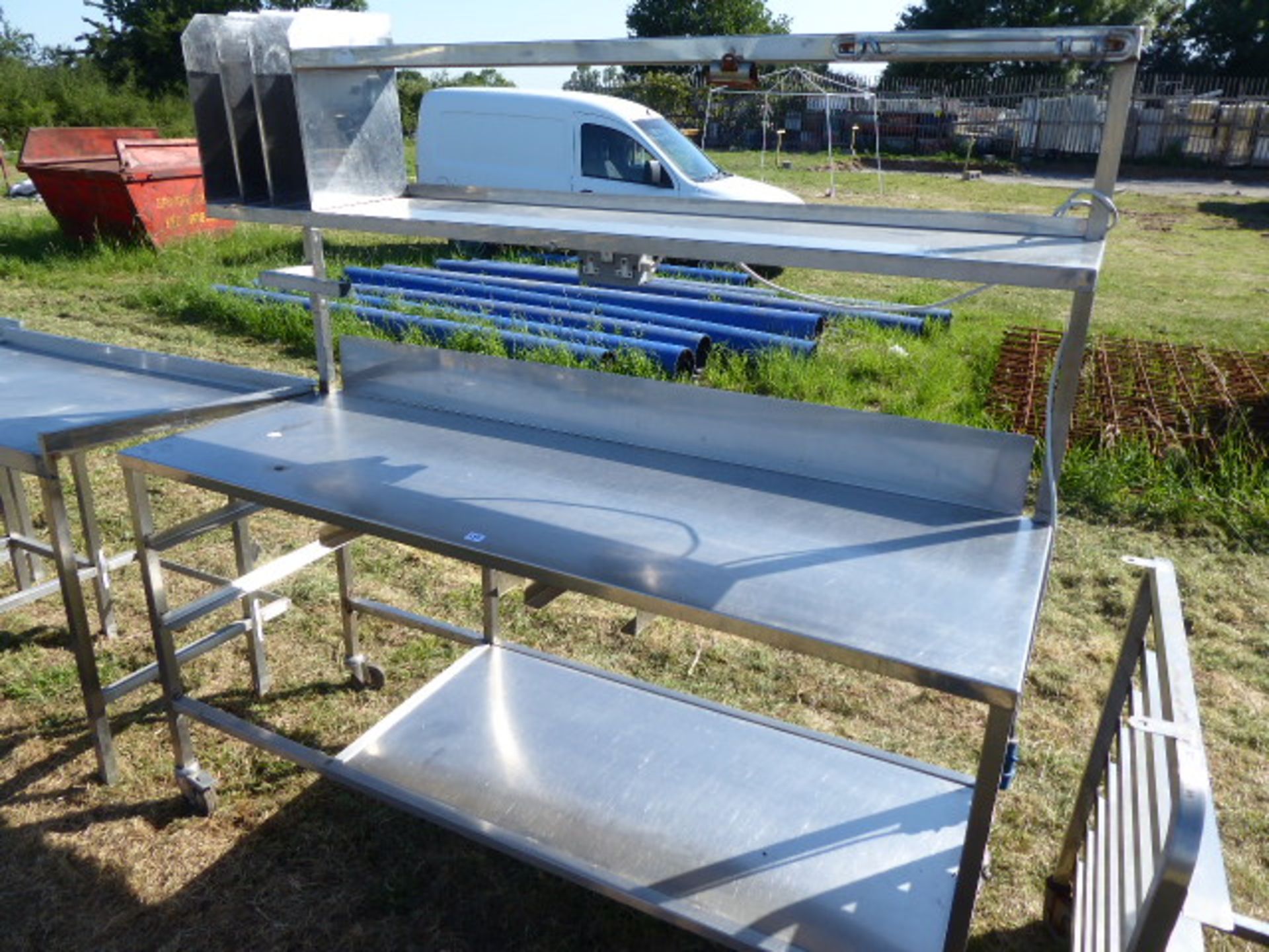 Stainless steel mobile food preparation station with 2 shelves over, shelf under space for trays,