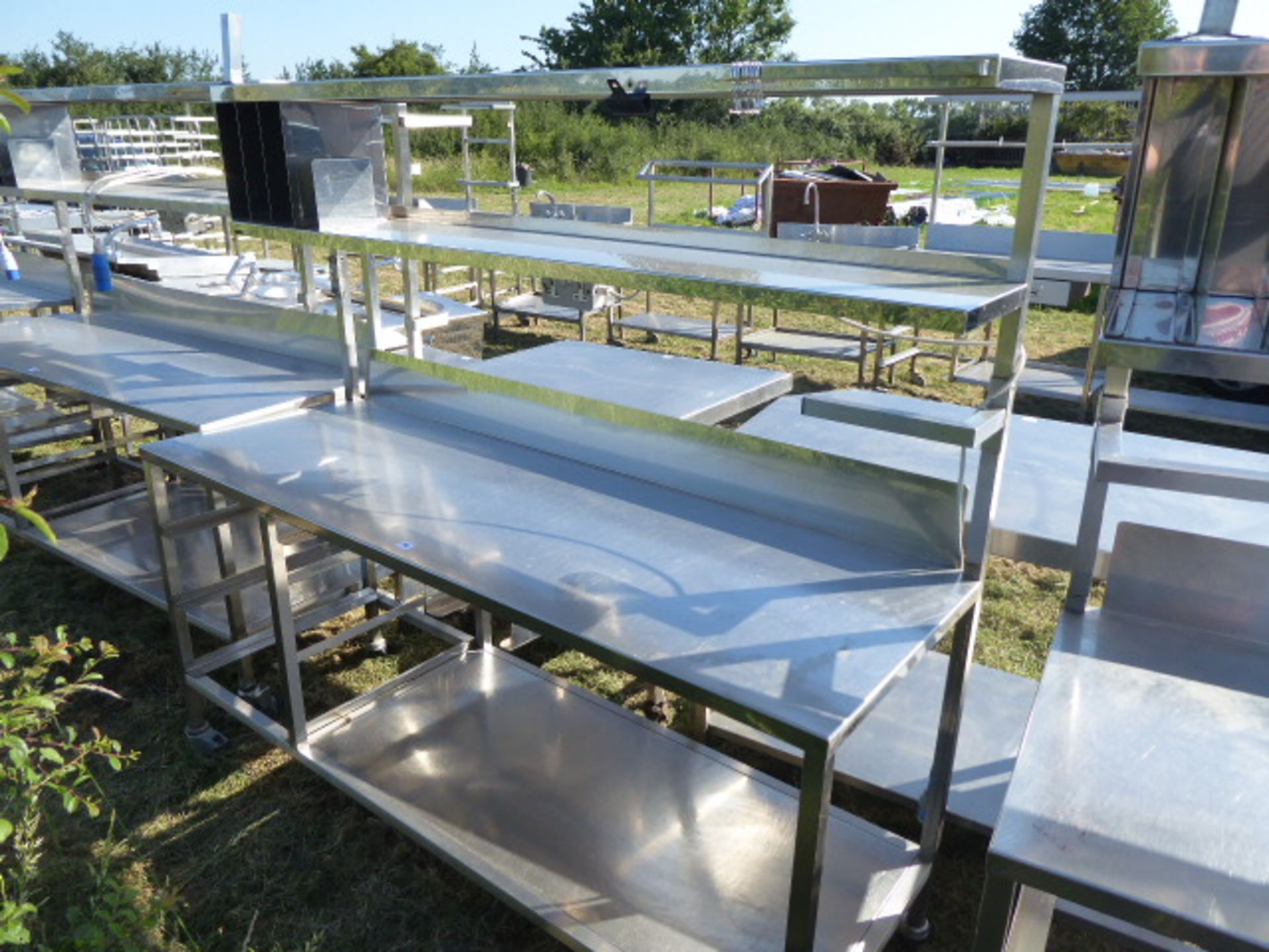 Stainless steel mobile food preparation station with 2 shelves over, shelf under space for trays,