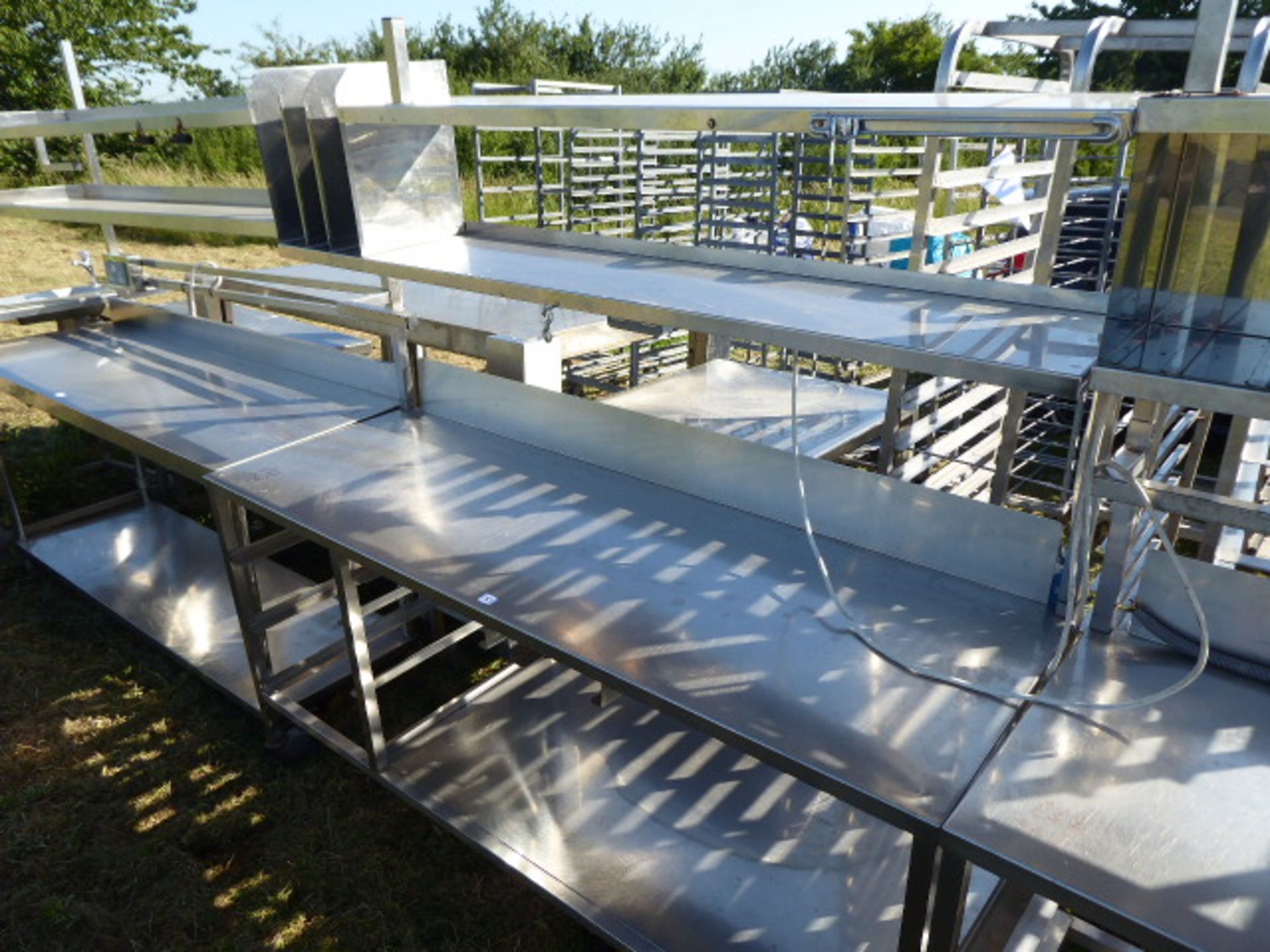 Stainless steel mobile food preparation station with 2 shelves over, shelf under space for trays,