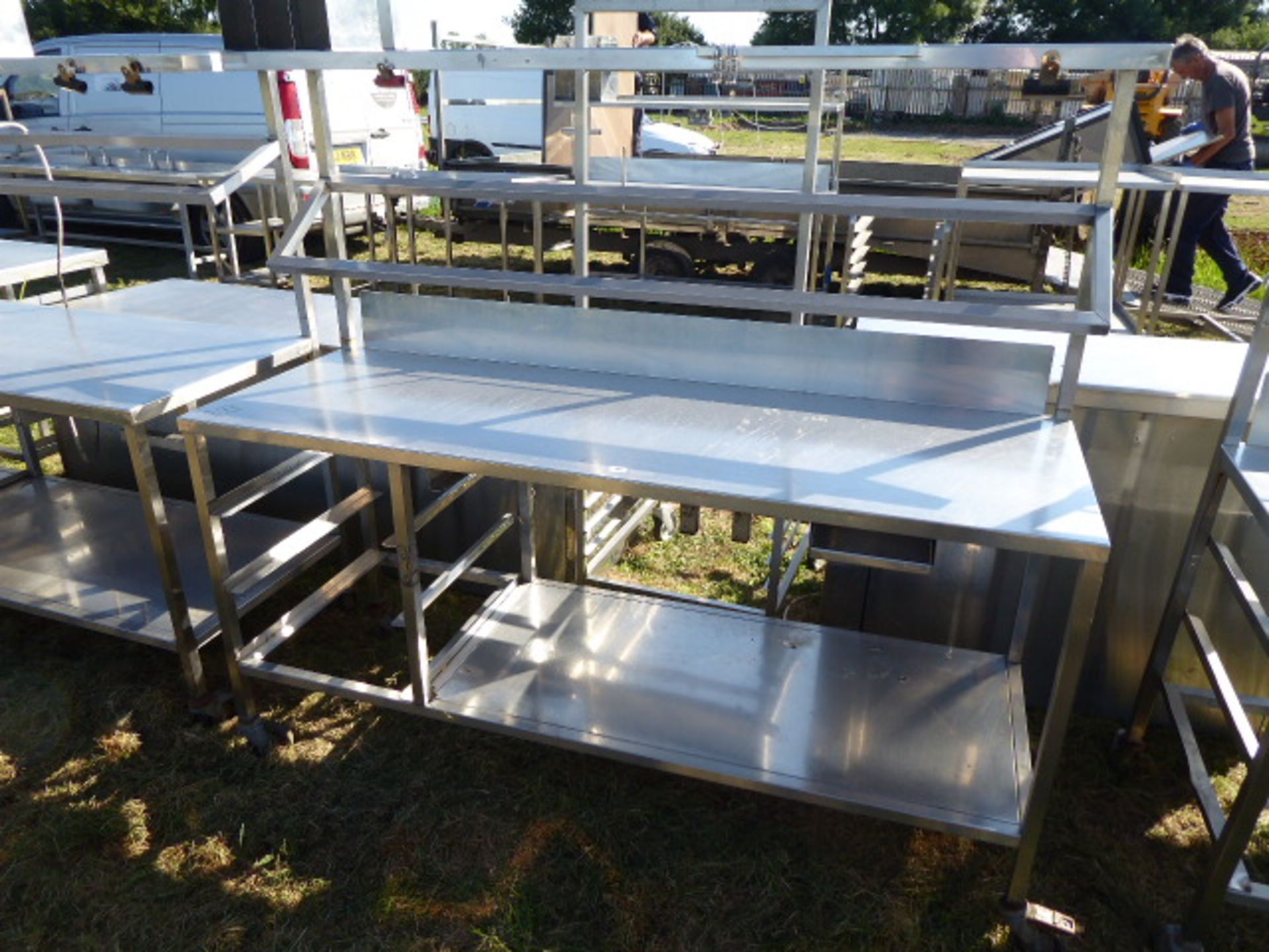 Stainless steel mobile food preparation station with 1 shelf over, shelf under space for trays and a