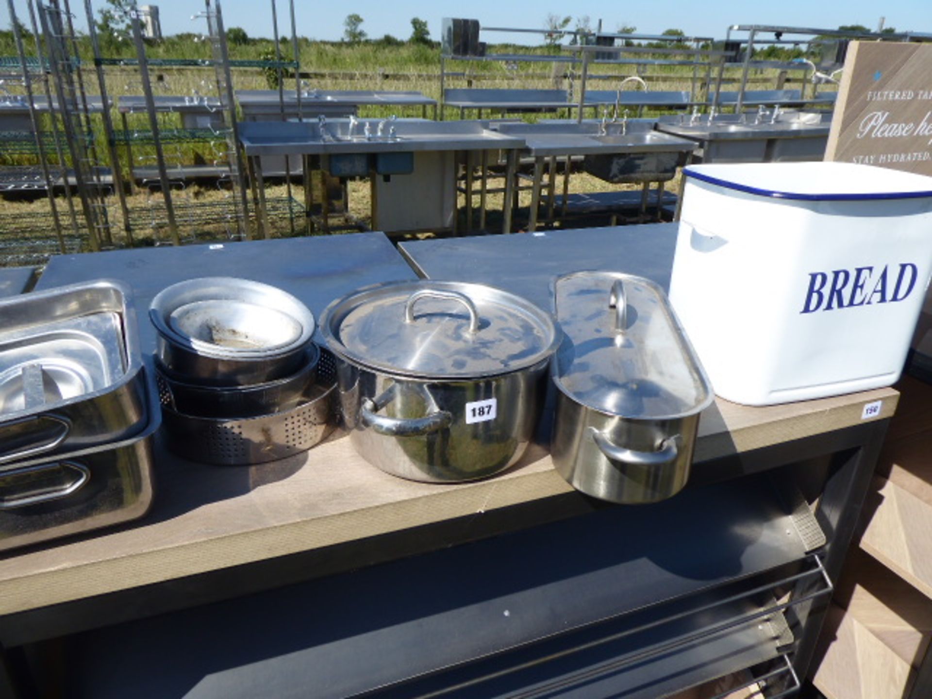 Shelf of items including stainless steel fish kettle, double handled cooking pot with lid, enamel