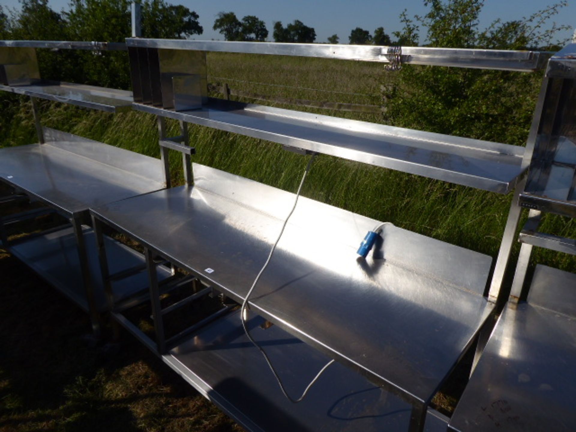 Stainless steel mobile food preparation station with 2 shelves over, shelf under space for trays,