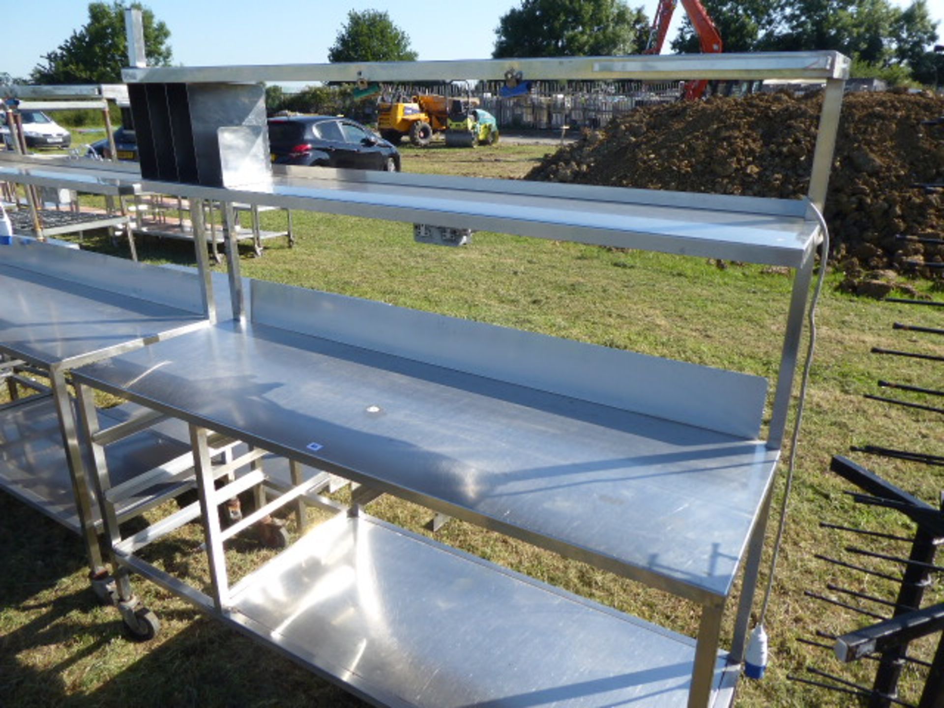 Stainless steel mobile food preparation station with 2 shelves over, shelf under space for trays,