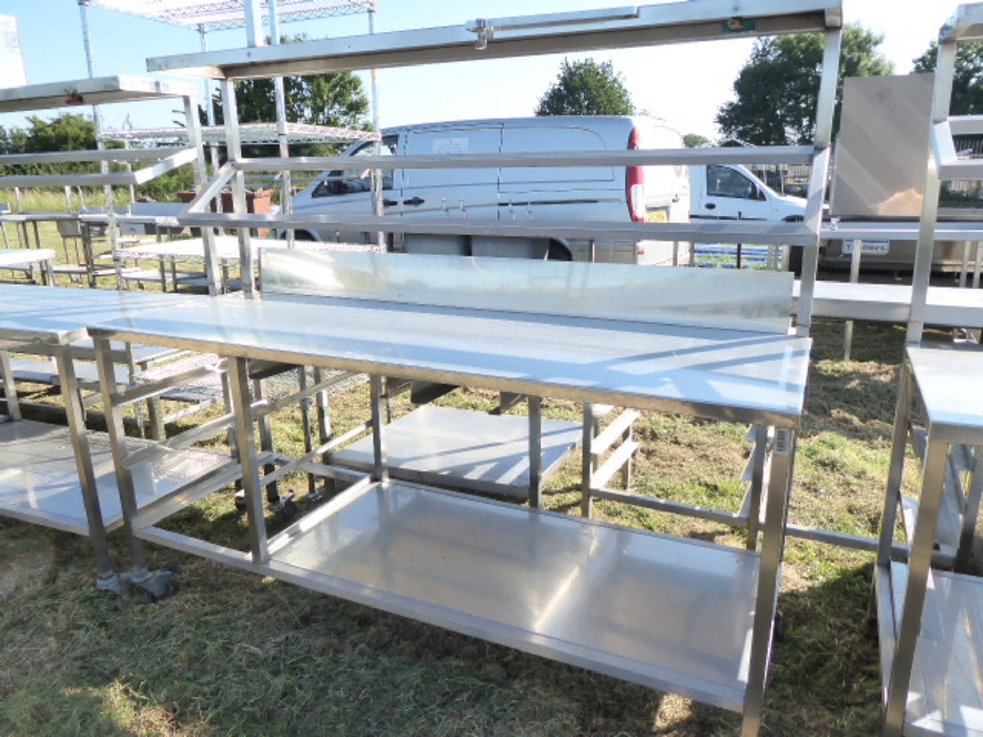 Stainless steel mobile food preparation station with 1 shelf over, shelf under space for trays and a